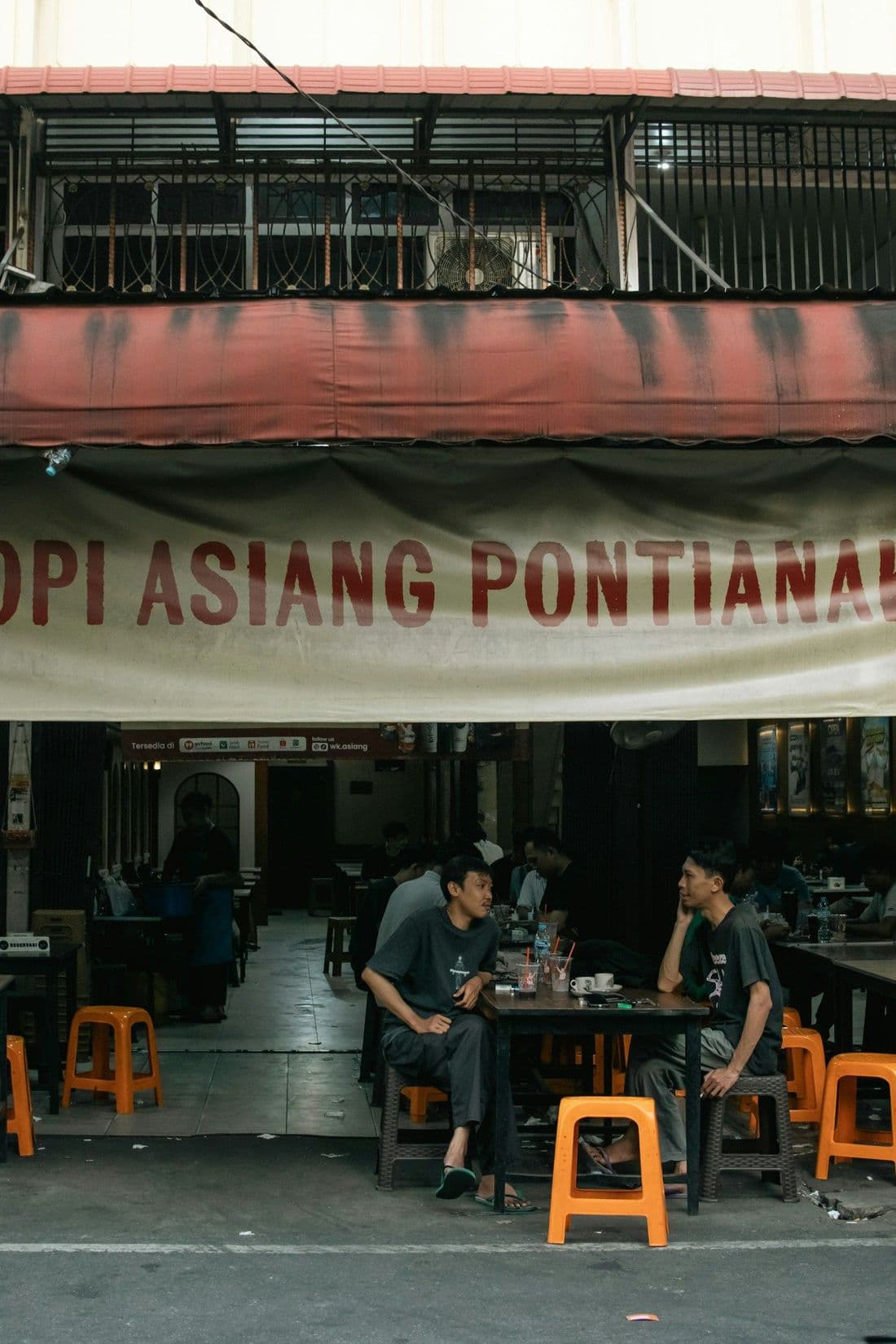 Dua pria berbincang di depan warung Kopi Asiang, Pontianak